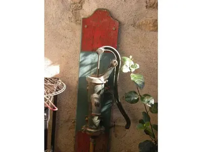 a metal object attached to a wall with a plant at 