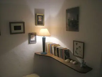 a lamp on a shelf with books on a wall at 