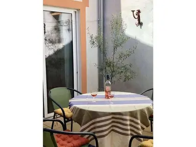 a table with chairs and a bottle of wine on it at Maison Marianne Comfortable holiday residence in Ferrals-lès-Corbières