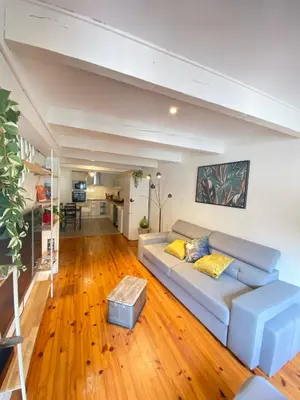 a living room with a couch and wooden floors at Maison de l'Ancienne Porte Neuve in Narbonne