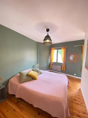 a bedroom with a large bed with a pink blanket at Maison de l'Ancienne Porte Neuve in Narbonne