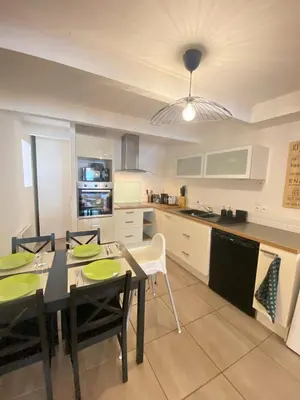a kitchen and dining room with a table and chairs at Maison de l'Ancienne Porte Neuve in Narbonne