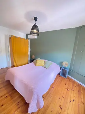 a bedroom with a white bed with a wooden floor at Maison de l'Ancienne Porte Neuve in Narbonne