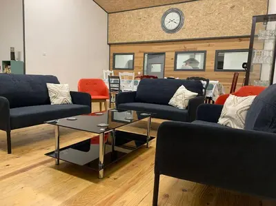 a living room with couches and a clock on a wall at La Coumereille in Belcaire