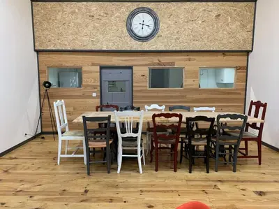 a dining room with a table and chairs and a clock at La Coumereille in Belcaire