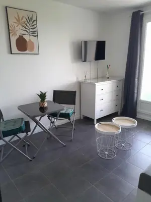 a living room with a table and chairs and a dresser at Studio Balcon Narbonne Centre in Narbonne