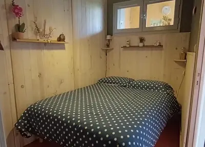 a room with a bed with a black and white comforter at Vue exceptionnelle tout en haut des montagnes, dépaysement total ! in Camurac