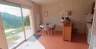 a kitchen with a table with chairs and a balcony at Vue exceptionnelle tout en haut des montagnes, dépaysement total ! in Camurac