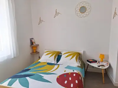 a bedroom with a bed and a white wall at Hébergements Narbonne centre - Local vélos et motos in Narbonne