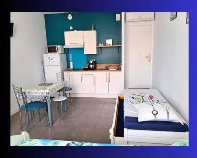 a small kitchen with a bed and a table at Hébergements Narbonne centre - Local vélos et motos in Narbonne