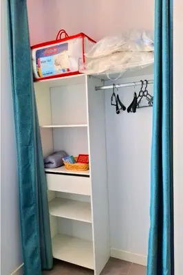 a bunk bed in a bedroom with blue curtains at Hébergements Narbonne centre - Local vélos et motos in Narbonne