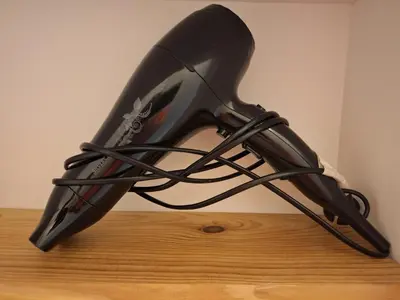 a hair dryer sitting on top of a wooden table at Hébergements Narbonne centre - Local vélos et motos in Narbonne