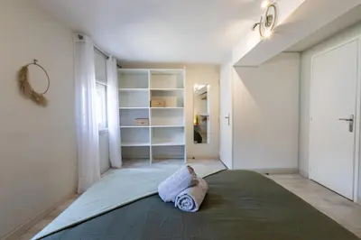 a bedroom with a large bed and white walls at Le Canopé - Duplex Confort, Hypercentre, 2 Salles d'eau in Castres
