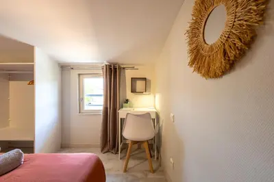 a bedroom with a bed and a mirror and a chair at Le Canopé - Duplex Confort, Hypercentre, 2 Salles d'eau in Castres