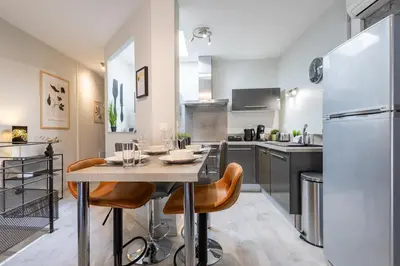 a kitchen with a table with chairs and a refrigerator at Le Canopé - Duplex Confort, Hypercentre, 2 Salles d'eau in Castres
