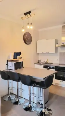 a kitchen with a table with chairs and a microwave at Superbe T2 cosy plein centre in Narbonne