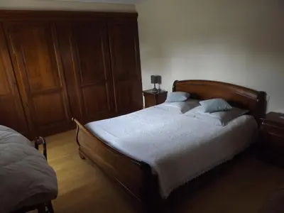 a bedroom with a bed with a wooden headboard at Chambres Sainte Anne in Carcassonne