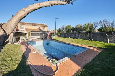 a swimming pool in the yard of a house at Chambres Sainte Anne in Carcassonne