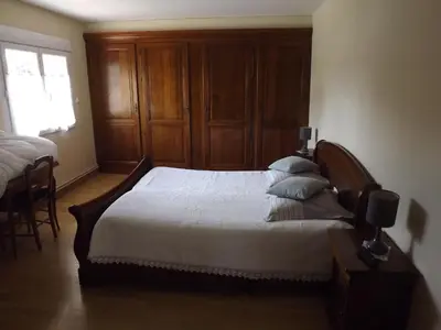 a bedroom with a large bed with a wooden headboard at Chambres Sainte Anne in Carcassonne
