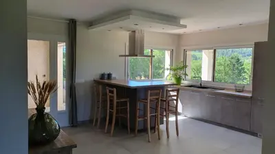 a kitchen with a large island with bar stools at Le Gîte de Berignac in Antugnac