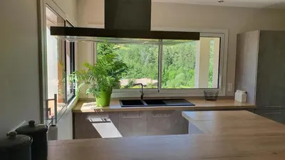a kitchen with a sink and a large window at Le Gîte de Berignac in Antugnac