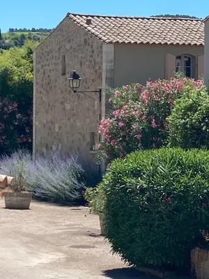 a garden with flowers and a building with a street light at Saint laurent de la cabrerisse Rivière proche Lagrasse in Saint-Laurent-de-la-Cabrerisse