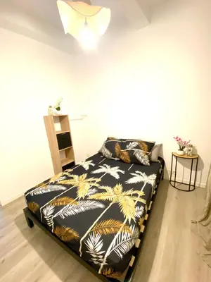 a bedroom with a bed with a black and gold comforter at La pinéa in Port-la-Nouvelle