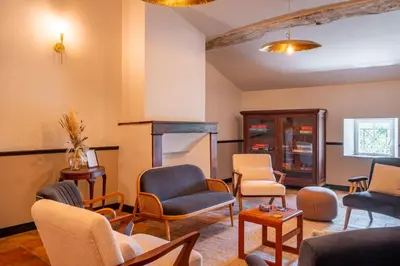 a waiting room with chairs and tables at Le Domaine de Camboyer, The Originals Collection in Montferrand