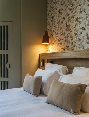 two beds with white sheets and pillows in a room at Le Domaine de Camboyer, The Originals Collection in Montferrand