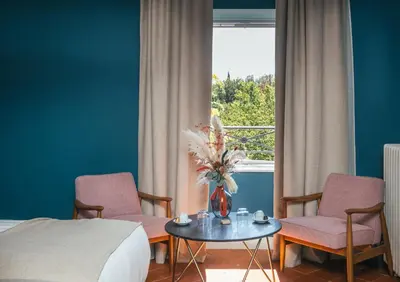 a hotel room with two chairs and a table and a window at Le Domaine de Camboyer, The Originals Collection in Montferrand