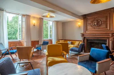 a waiting room with chairs and a fireplace at Le Domaine de Camboyer, The Originals Collection in Montferrand