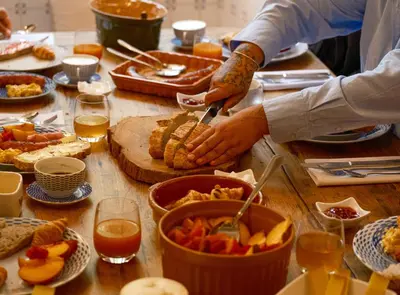 a table full of food with people preparing food at Le Domaine de Camboyer, The Originals Collection in Montferrand