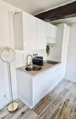a kitchen with a sink and a lamp in a room at 4-Pieds Cité - Barbacane - Historique - Romantique - Clim in Carcassonne