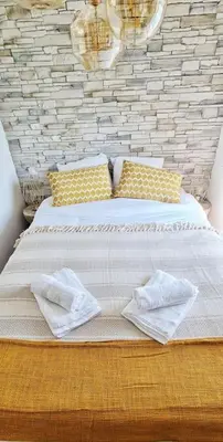 a bedroom with a large bed with yellow pillows at 4-Pieds Cité - Barbacane - Historique - Romantique - Clim in Carcassonne