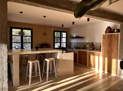 a kitchen with a large island with bar stools at Maison Bacchus, gîte insolite dans cuve à vin in Caves