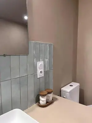 a bathroom with a sink and a toilet and a mirror at Maison Bacchus, gîte insolite dans cuve à vin in Caves