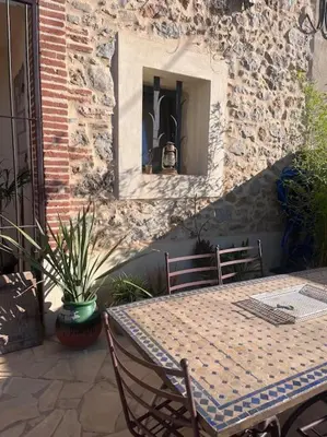 a table and chairs sitting on a patio at Maison Bacchus, gîte insolite dans cuve à vin in Caves