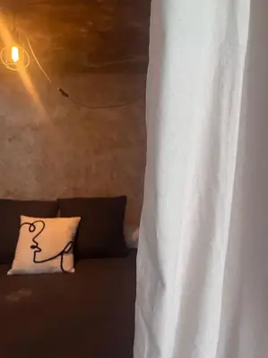 a couch with a pillow with a drawing on it at Maison Bacchus, gîte insolite dans cuve à vin in Caves