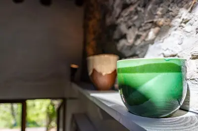 a green bowl sitting on a counter with two vases at Secluded home in Le Caunil in Salvezines
