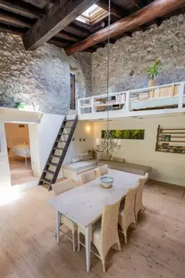 a room with a table and chairs and a staircase at Secluded home in Le Caunil in Salvezines