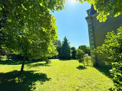 a green yard with a tree and a building at Château Mesdames in Labastide-Rouairoux