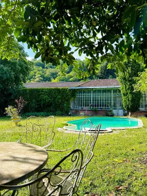 a table and chairs in a yard with a swimming pool at Château Mesdames in Labastide-Rouairoux