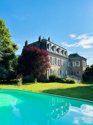 a large house with a swimming pool in front of it at Château Mesdames in Labastide-Rouairoux