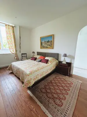 a bedroom with a bed and a rug on the floor at Château Mesdames in Labastide-Rouairoux