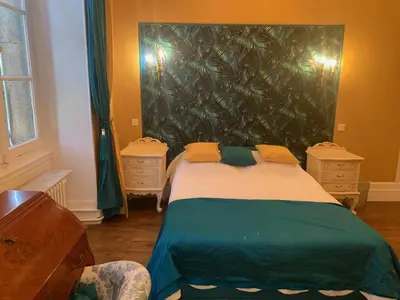 a bedroom with a large bed with yellow pillows at Château Mesdames in Labastide-Rouairoux