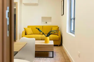 a living room with a yellow couch and a table at T2 Ed Warner in Narbonne