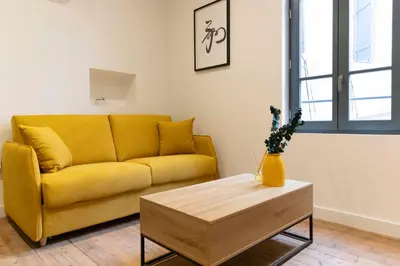 a living room with a yellow couch and a coffee table at T2 Ed Warner in Narbonne