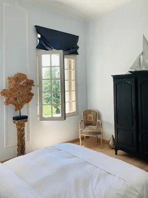 a bedroom with a bed and a chair and a window at Château Suite in Saint-Marcel