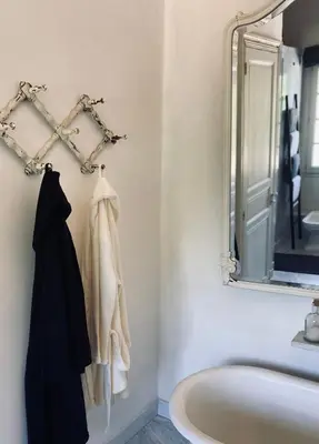 a bathroom with a bath tub and a mirror at Château Suite in Saint-Marcel