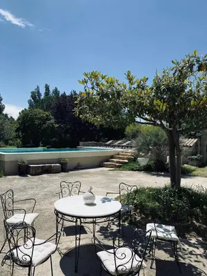 a patio with a table and chairs and a tree at Château Suite in Saint-Marcel